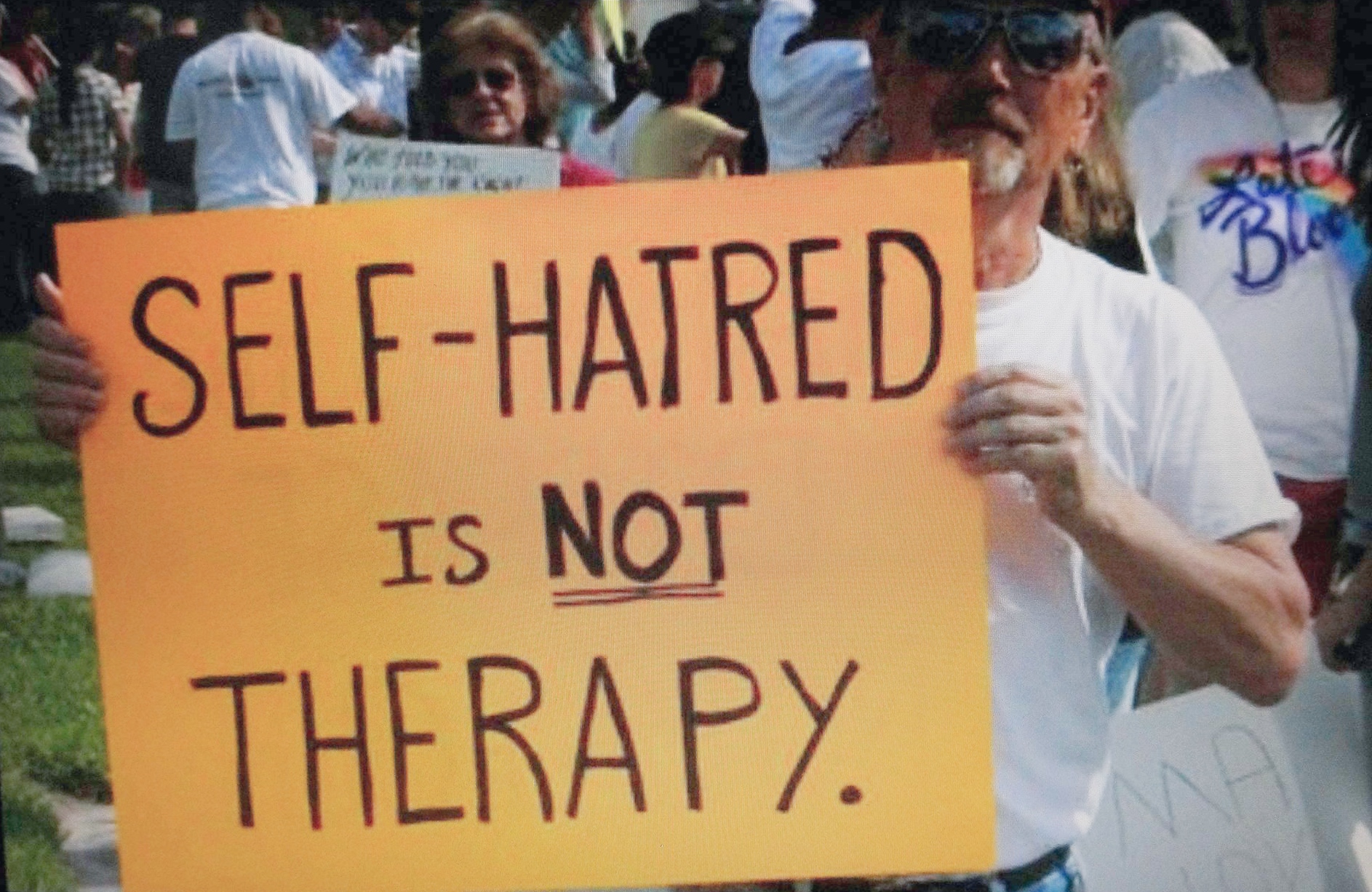 A man holds a sign that reads 
